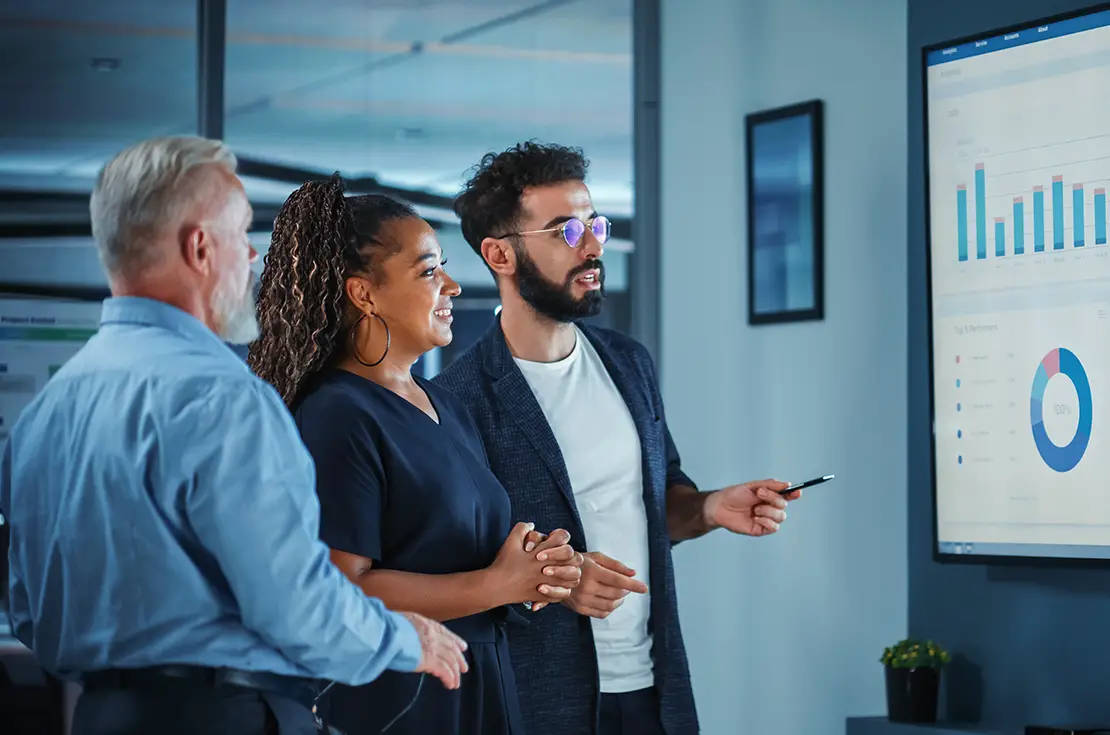 Three professionals engaged with a computer screen, showcasing the integration of knowledge types in management.